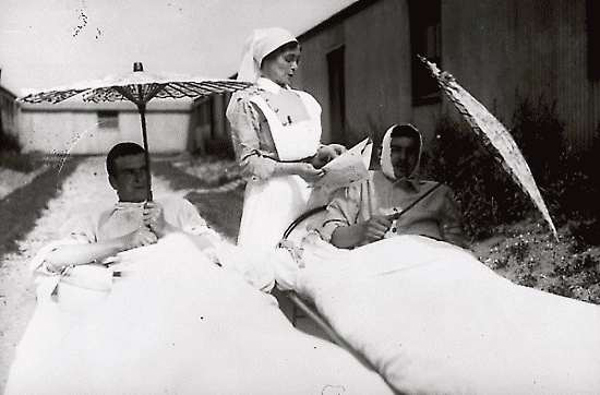 Wounded Canadians in France with sister reading, July 1917. Library and Archives Canada PA-001613 