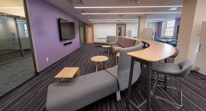 A view of the wall-mounted LCD  Screen curved table and seating accommodations in the innovation hub