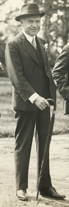 Lord Beaverbrook standing with a cane