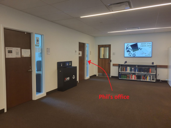 Photo of south corner of Commons first floor, with an arrow indicating Phil's office, number 116 along the left wall