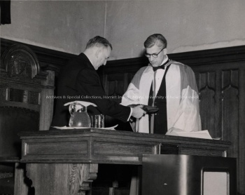 UNB President Albert Trueman paying quit rent to Lieutenant Governor David MacLaren in Memorial Hall, [between 1948-1953]. UA PC 9a no.25 (b).