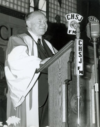 Lord Beaverbrook speaking at a podium